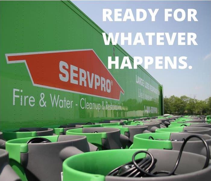 SERVPRO semi truck with several green air movers in front of it.